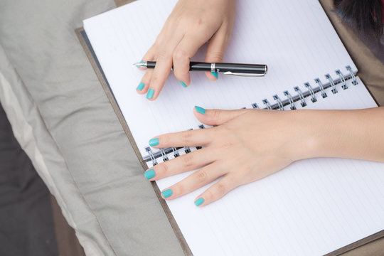Women hand writing on blank notebook