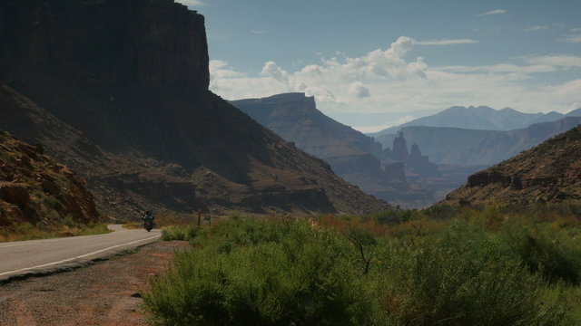 A motorcycle passing by on a scenic highway through a canyon