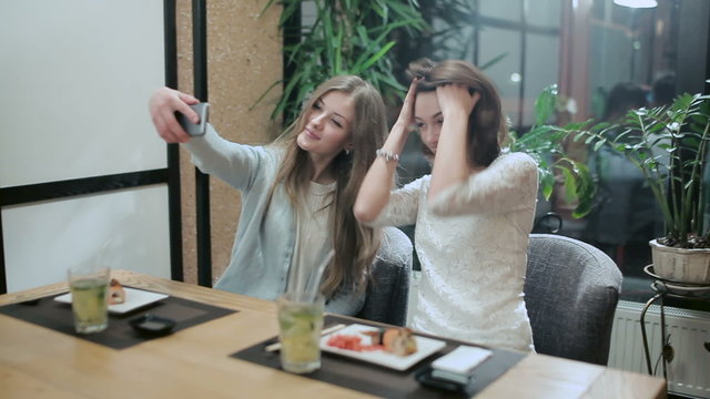 Two girls taking selfies in japanese restaurant