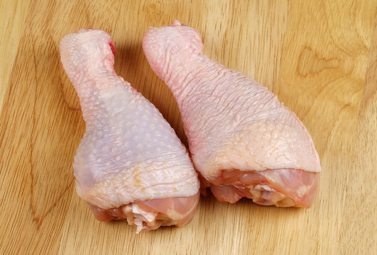 Fresh chicken legs on a cutting board - close up