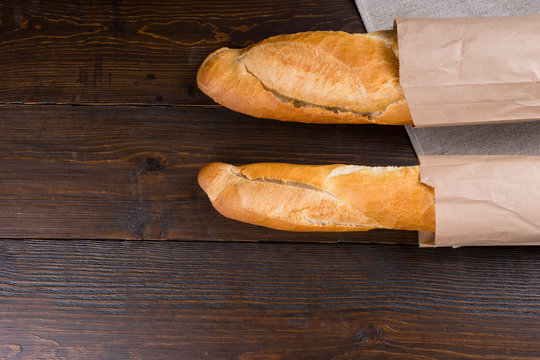 Twin loaves of french bread in bags