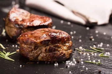 Plexiglas foto achterwand Gegrild steak vlees (mignon) op het donkere oppervlak © zakiroff