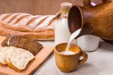 Person pouring fresh creamy farm milk