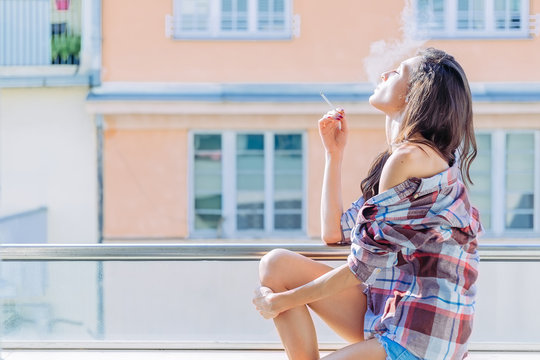 Girl smoking on the balcony
