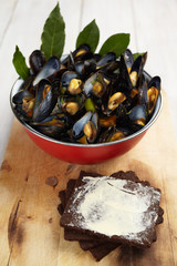 Fresh homemade cooked mussels with carrots and leek, bread and butter