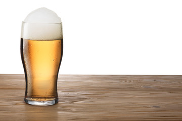 Glass of light beer on wooden table