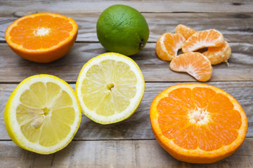 Fototapeta na wymiar several mature citrus on a wooden table - lemon, lime and tangerine 