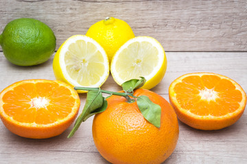 several mature citrus on a wooden table - lemon, lime and tangerine

