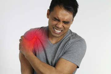young man suffering from shoulder pain over a white background