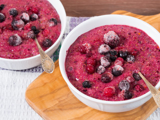 Chia puding with almond milk, banana and frozen wild berries  - blueberries, blackberries, raspberries and creanberries in a bowl