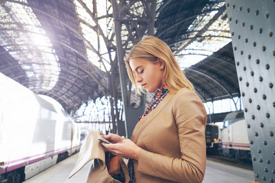 young attractive businesswoman booking of train tickets online.beautiful young blond woman writes a message to a friend with information about their train