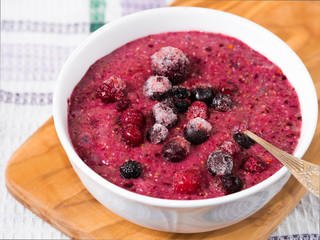 Chia puding with almond milk, banana and frozen wild berries  - blueberries, blackberries, raspberries and creanberries in a bowl
