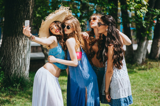 four beautiful girls hippies doing selfie outdoors