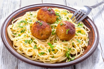 Spaghetti pasta with meatballs sprinkled with chopped parsley , top view