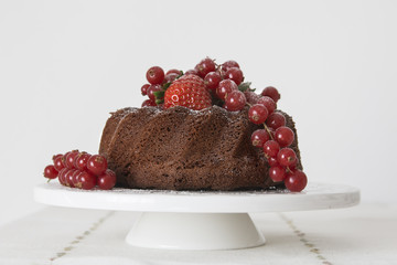 Chocolate cake with fresh berries set in a white tableware