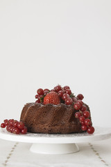 Chocolate cake with fresh berries set in a white tableware