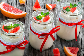 yogurt with grapefruit and mint in a glass jars, closeup
