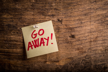 go away! - motivation paper note on wood noticeboard

