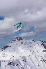 Naklejka na ściany i meble Snowboarder making jump, extreme mountain freeride.