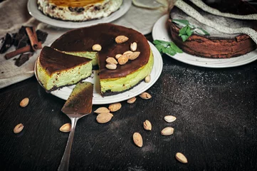 Selbstklebende Fototapeten slicing dessert pistachio pie on dark background  © glazok