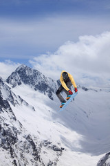 Fototapeta na wymiar Snowboarder making jump, extreme mountain freeride.