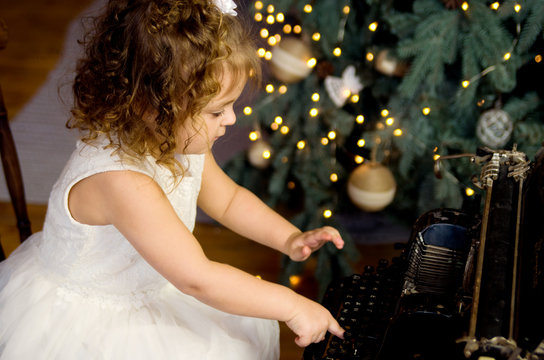 Little girl typing on a typewriter