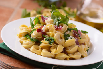 tortellini ripieni di carne con rucola e cipolla rossa