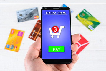 Man's hand holding a smart phone and credit card