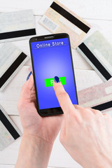 Woman holds a smartphone and pay for goods in the online store