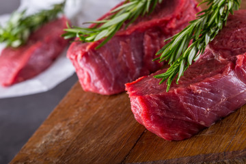 Steak. Raw beef steak. Fresh raw Sirloin beef steak sliced or whole ready for BBQ or grill. Herb - Rosemary decoration.