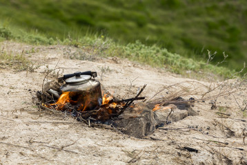 Teapot in Iraqi countryside with burnig wood under it