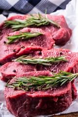 Steak. Raw beef steak. Fresh raw Sirloin beef steak sliced or whole ready for BBQ or grill. Herb - Rosemary decoration.