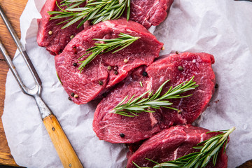 Steak. Raw beef steak. Fresh raw Sirloin beef steak sliced or whole ready for BBQ or grill. Herb - Rosemary decoration.