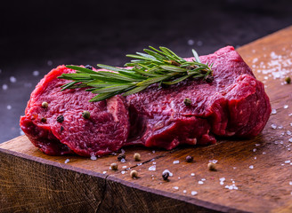 Steak. Raw beef steak. Fresh raw Sirloin beef steak sliced or whole ready for BBQ or grill. Herb - Rosemary decoration.