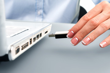 Secretary's hand inserts flash drive. 