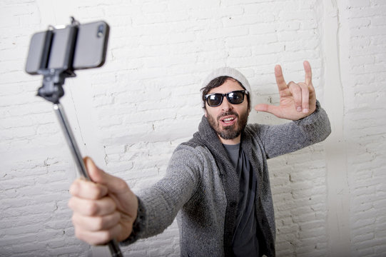 young hipster trendy blogger man holding stick recording selfie video in vlog concept