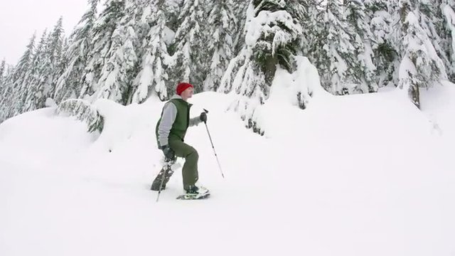 Steadicam of Man Snowshoeing Through Deep Powder in Mountain Forest