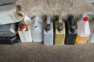 group of dirty plastic container against a wall, in a workshop.