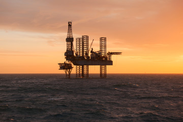 Silhouette of an drilling rig at sunset