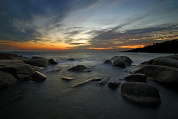 Fototapeta na wymiar sunset over the sea mist on rocks