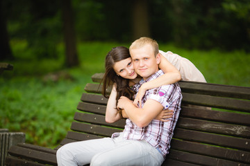 Attractive couple sitting on bench in the park