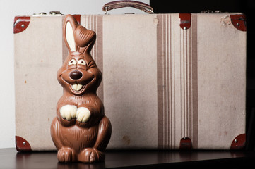 Chocolate bunny of Easter, with a suitcase