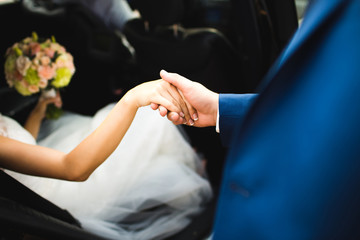 bride's and groom's hands while getting out of car