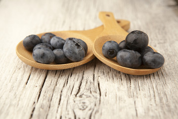Fototapeta na wymiar Fresh blueberries on wooden spoons