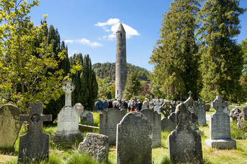 Roundtower with graveyards and tombstones in the foreground Glendalough Ireland - obrazy, fototapety, plakaty