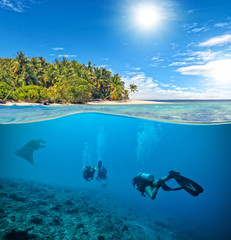 Underwater coral reef with scuba divers and manta