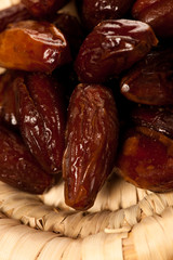 Sweet dried dates fruit in small bowl, mediterranean desert on w