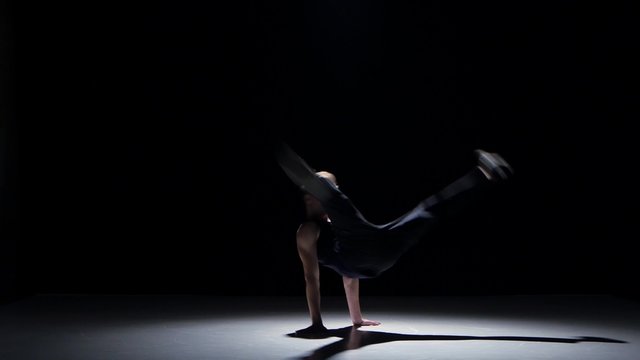 Young blonde dancer man dancing breakdance on black