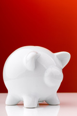 White piggy bank on red background