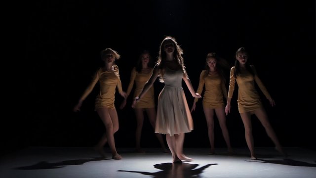 Five beautiful girls start dancing modern contemporary dance, on black, shadow